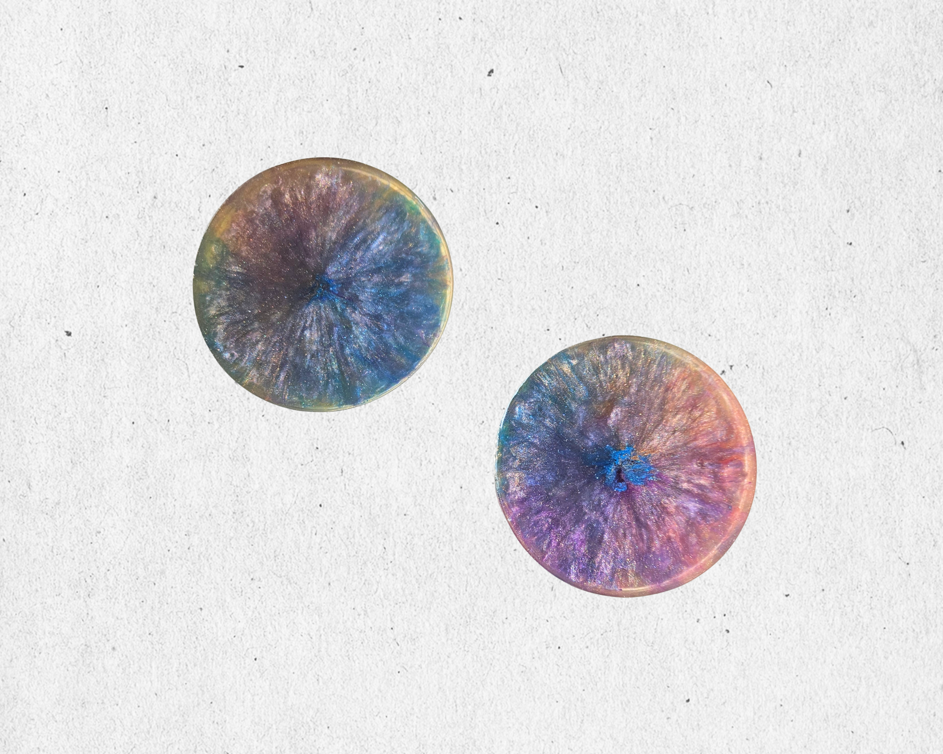 Handmade set of 2 resin coasters with blues, purples, and gold crystal-burst patterns.