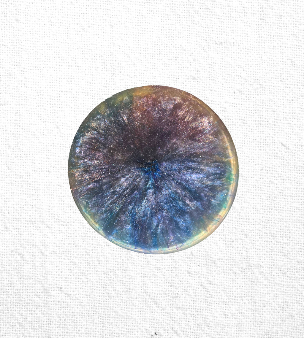 Handmade resin coaster with blues, purples, and gold crystal-burst patterns.