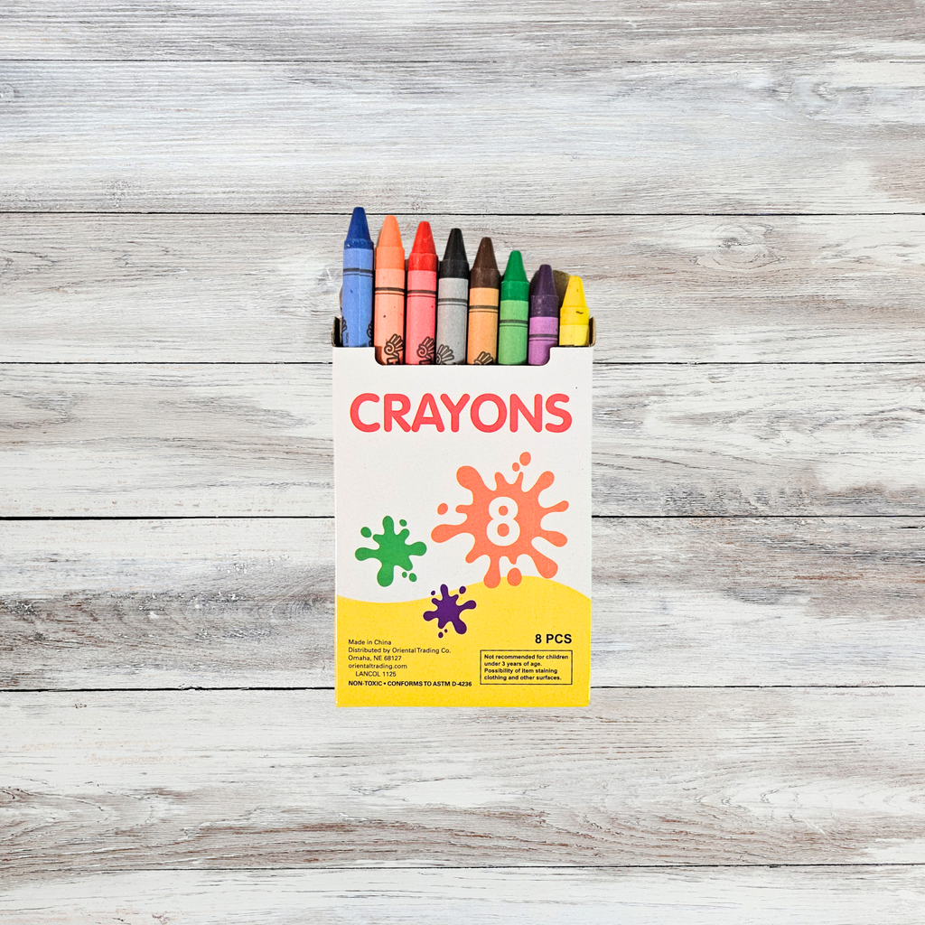 8 colorful crayons sticking out of their box on a wooden surface