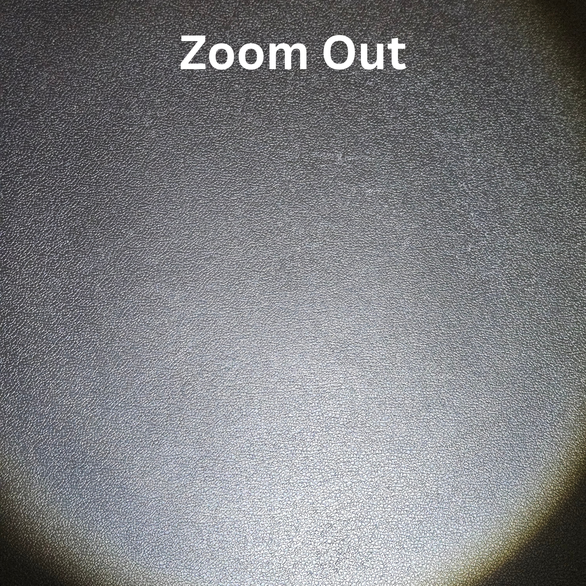 Textured dark surface with a bright light source covering whole area, labeled 'Zoom Out'.