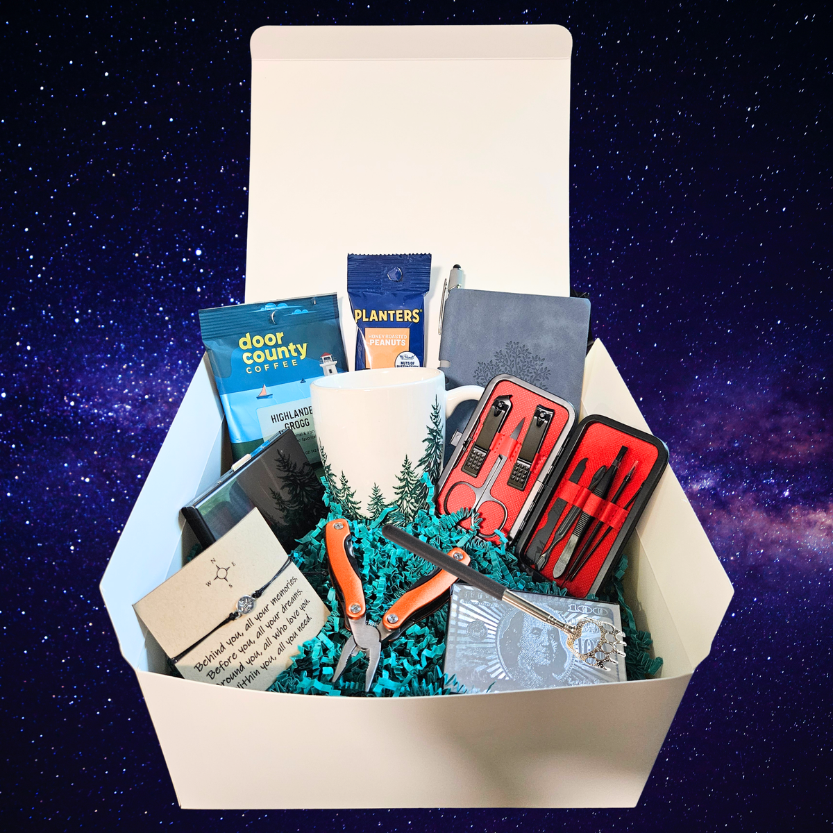 A curated gift box filled with various items including a white mug with a pine tree design, door county highlander grogg coffee, Planters peanuts, a multi tool, credit card carry case, boho bracelet, deck of cards, back scratcher, mini journal and manicure set, set against a starry night sky background.