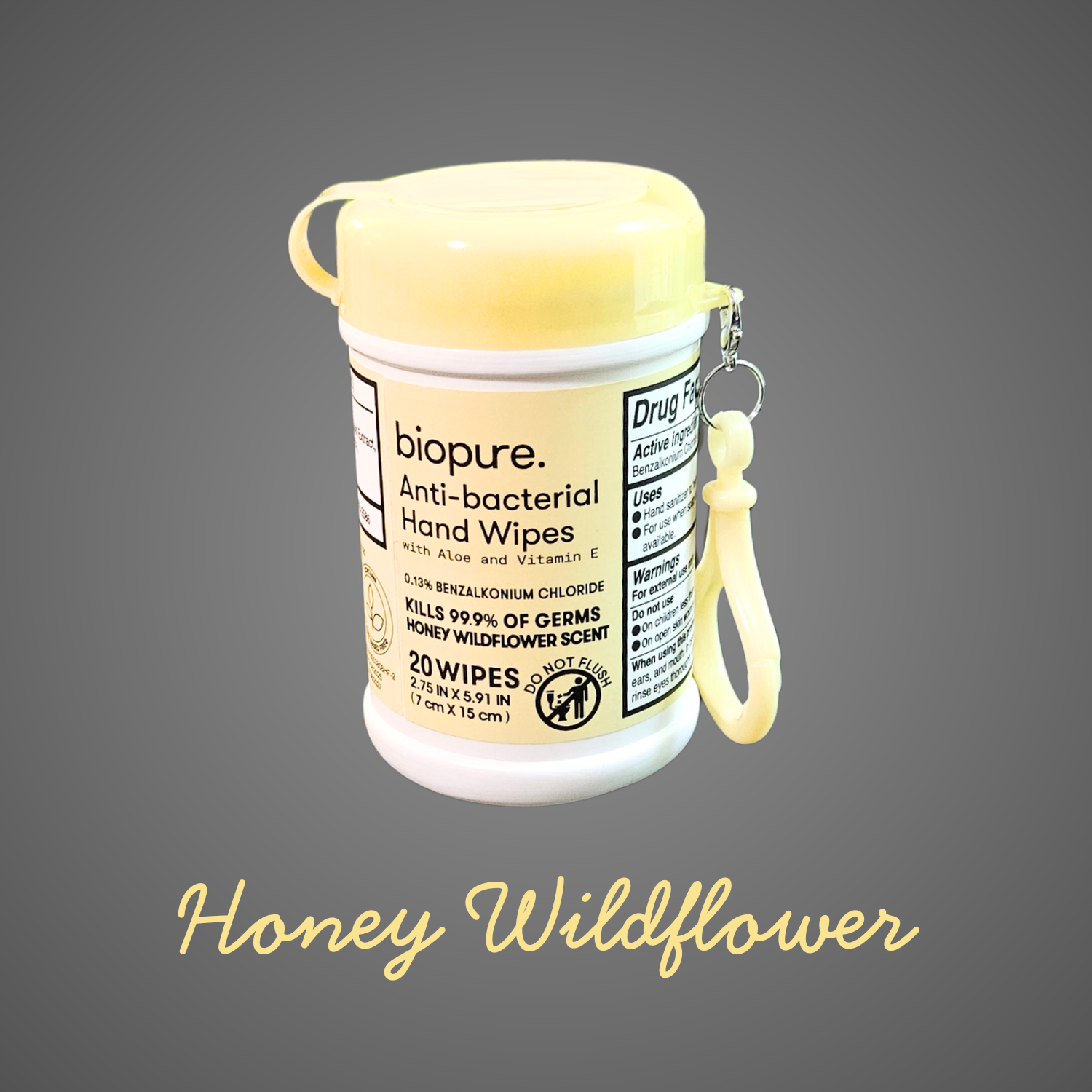 A yellow-lidded container of BioPure anti-bacterial hand wipes with a matching carry clip, displayed on a gray background with “Honey Wildflower” written underneath in cursive.