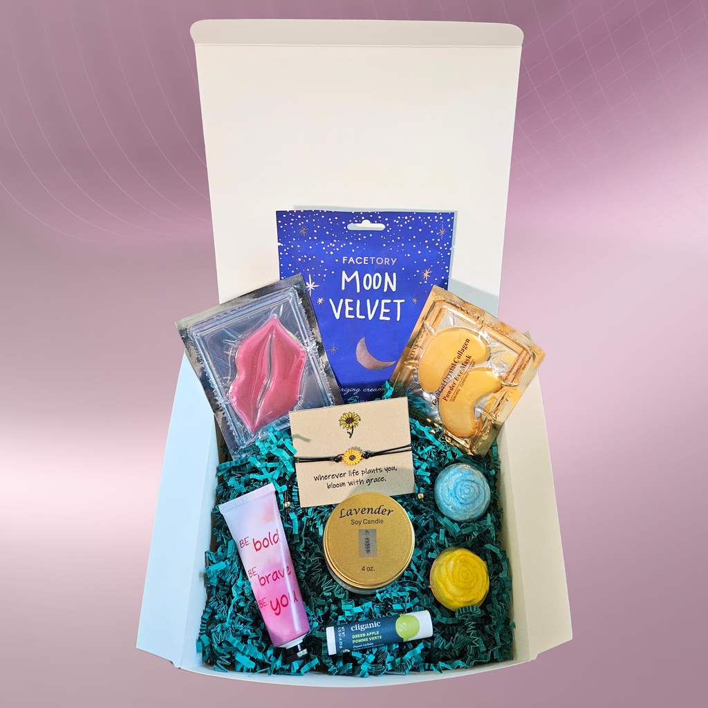 A self‑care gift box filled with items like face masks, a lip mask, eye mask, lavender candle, lip balm, bath bombs, and a sunflower bracelet arranged on teal filler against a pink‑purple background.