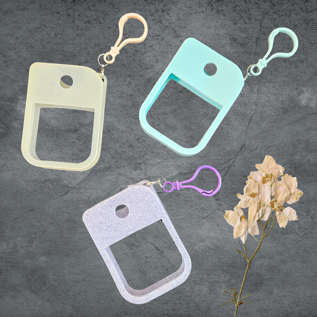 three different colors of hand sanitizer holders with clips on a gray background   