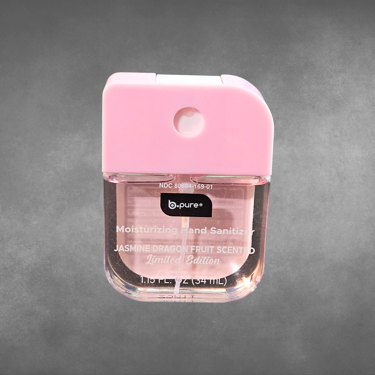 Pocket size jasmine dragon fruit scent pink spray hand sanitizer on a gray background.