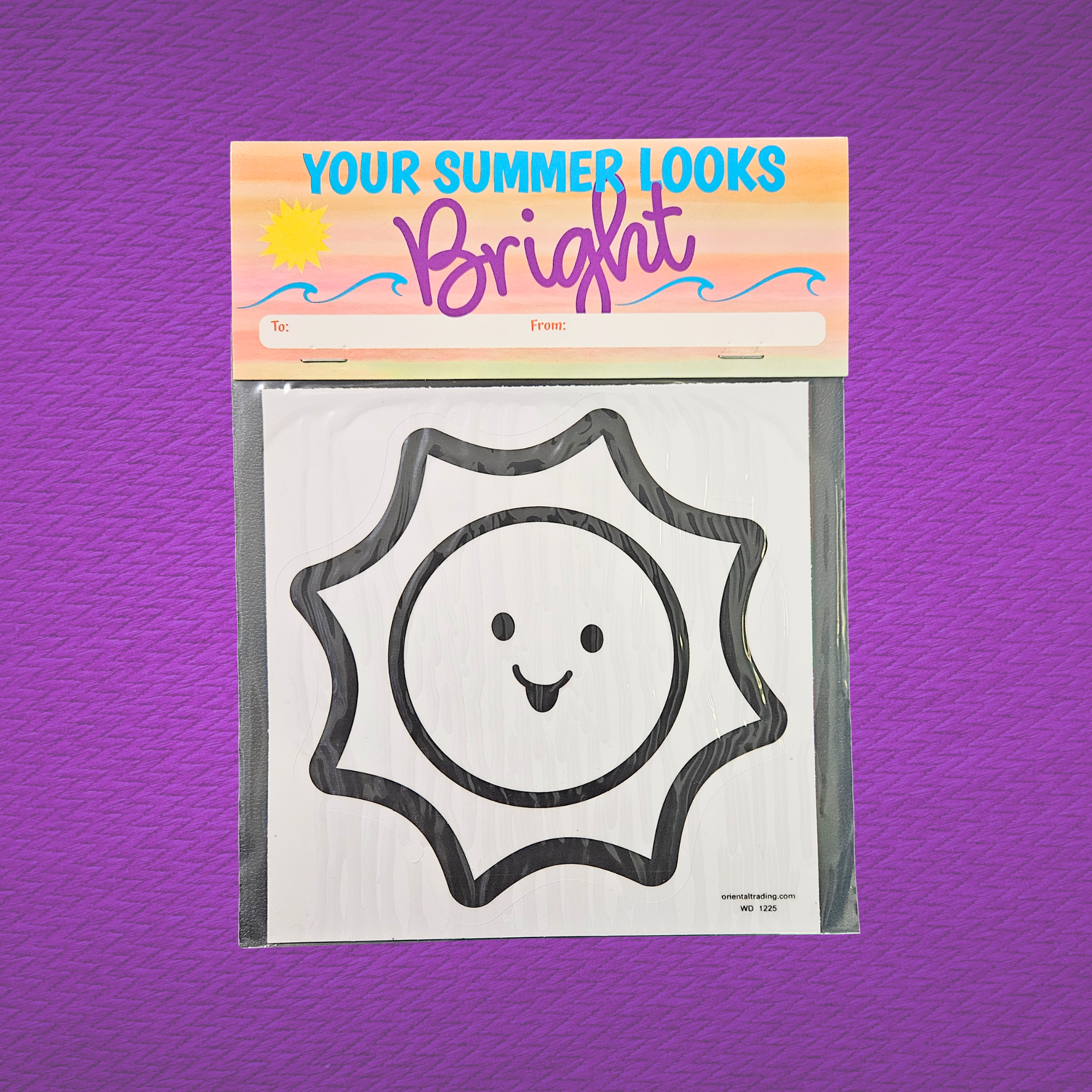 Packaged sun-shaped window cling with 'Your Summer Looks Bright' text on a purple background