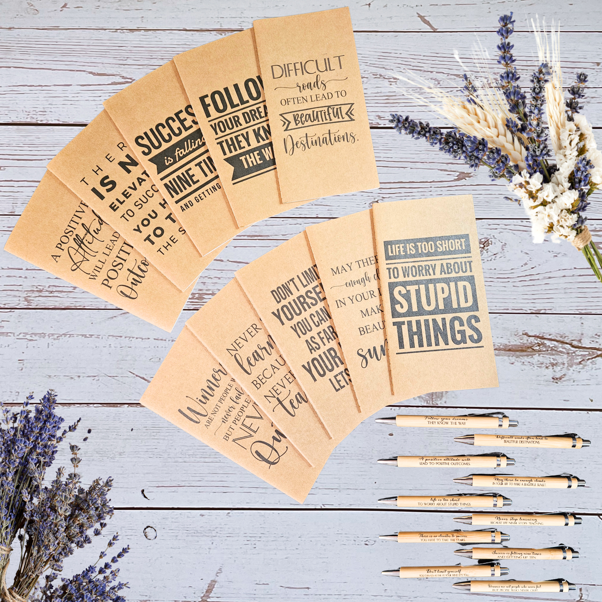 Motivational weekly planners and pens on a wooden surface with lavender flowers.